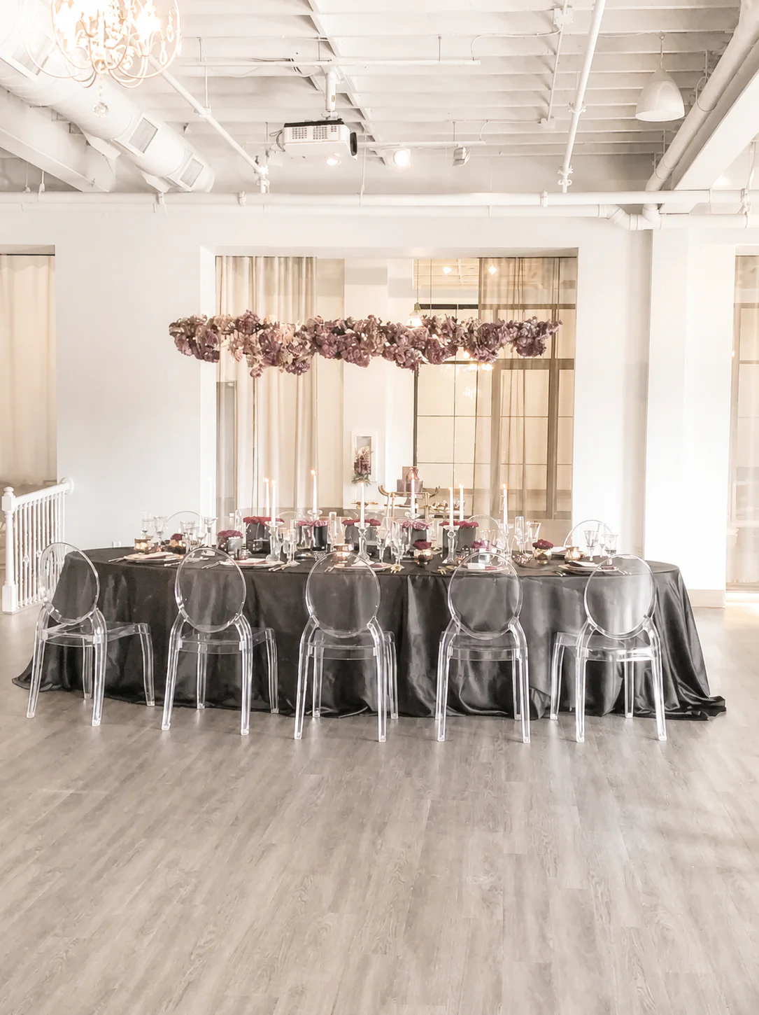 A candlelit head table beneath suspended flowers inside The Sterling Room